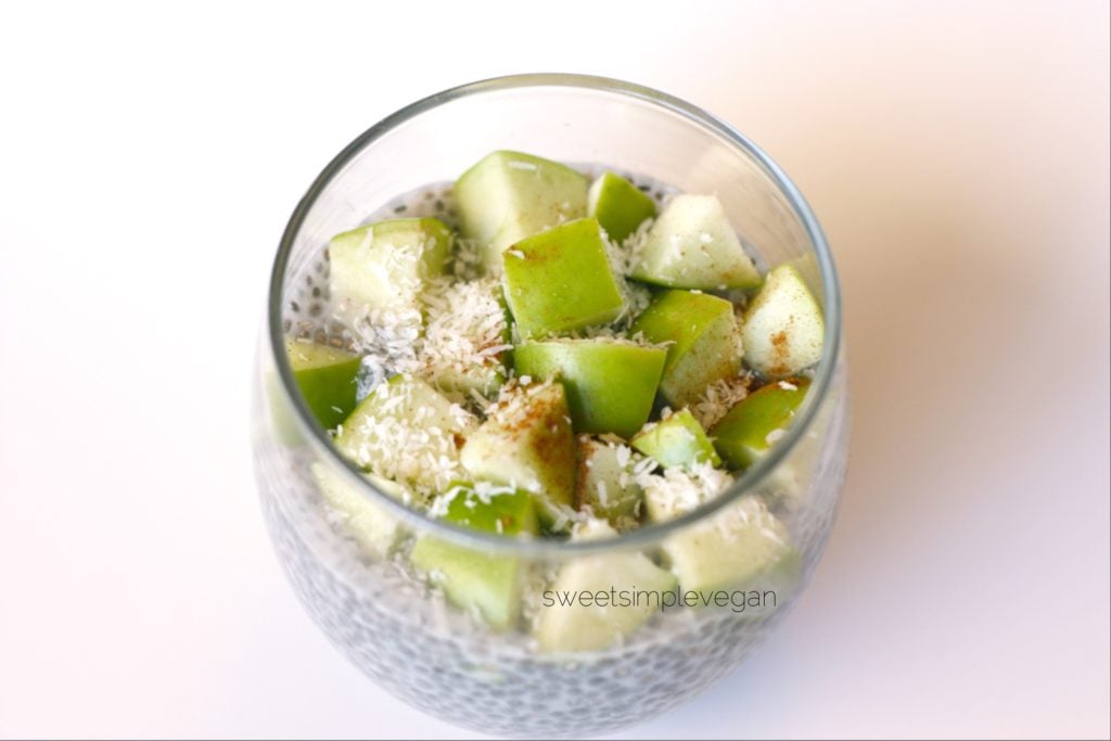 Apple cinnamon chia pudding in a cup with coconut flakes on top by Sweet Simple vegan