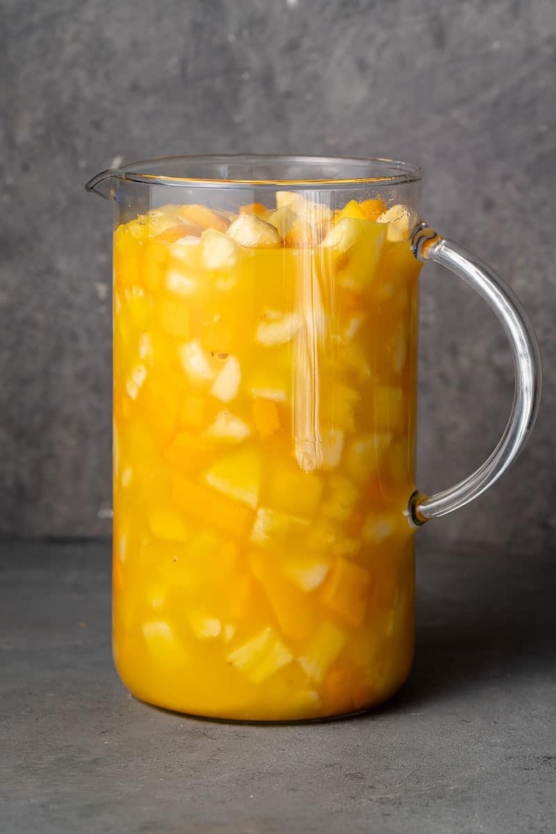 a tall pitcher filled with come y bebe ecuadorian fruit salad