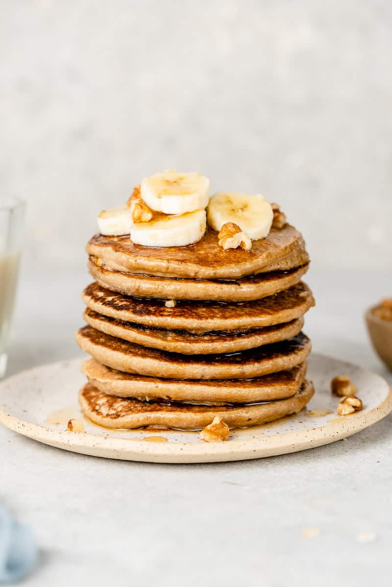 a stack of 3-ingredient vegan pancakes with bananas and walnuts on top