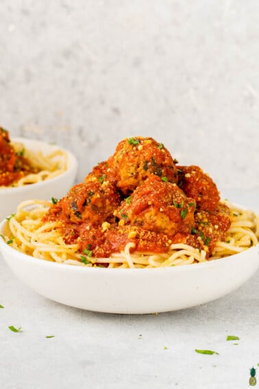 spaghetti and vegan eggplant meatballs in a white bowl by sweet simple vegan