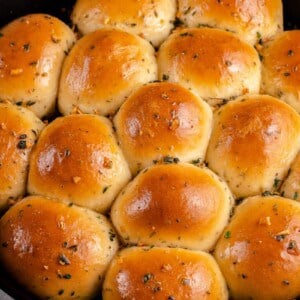 golden dinner rolls with herbs in a cast iron skillet