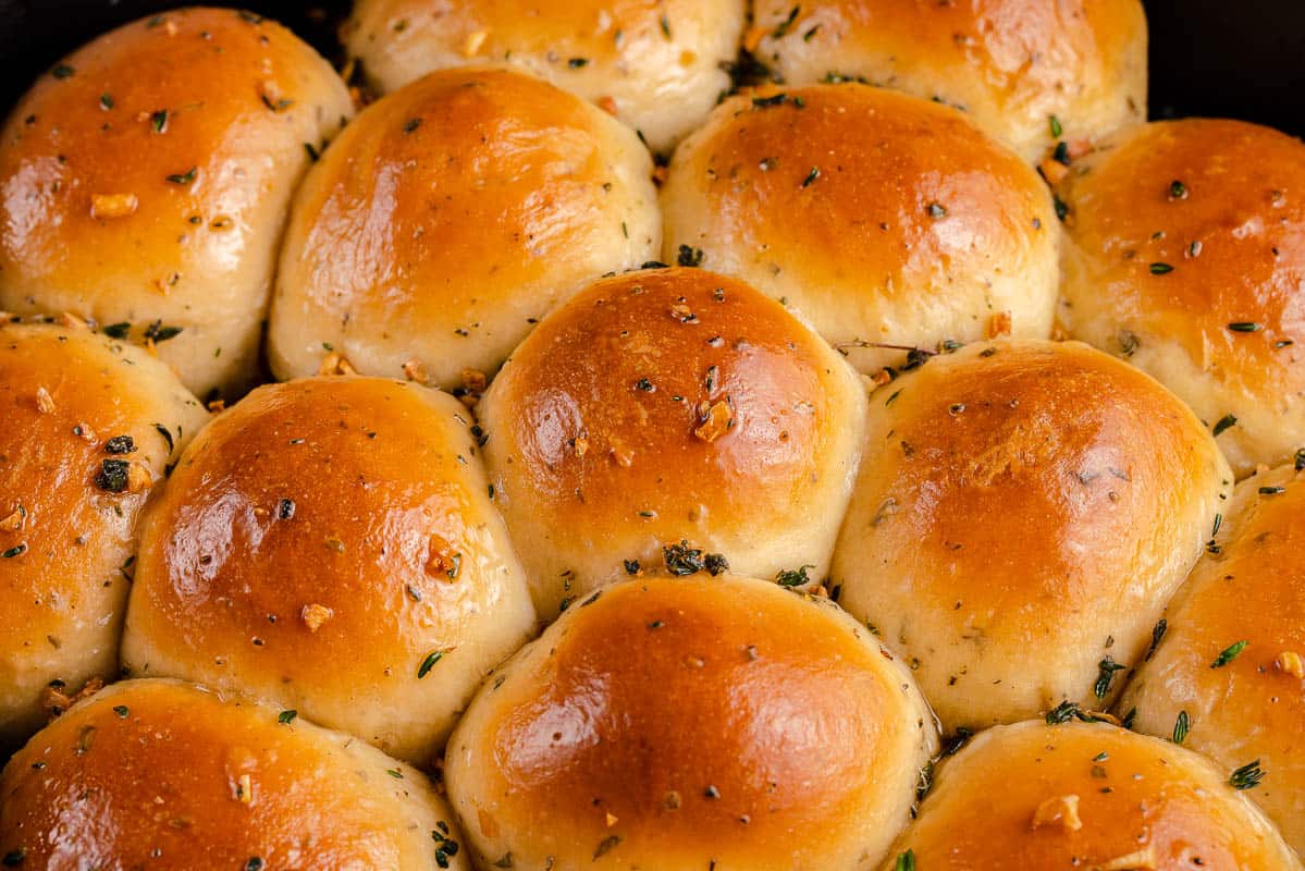 golden dinner rolls with herbs in a cast iron skillet