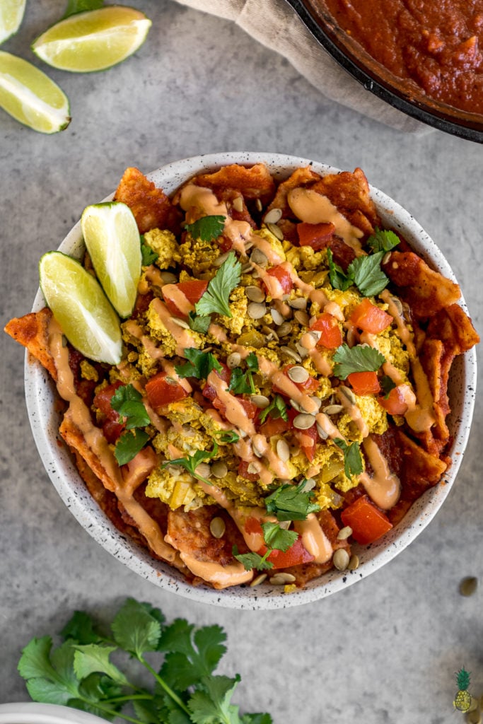 These vegan chilaquiles are spot on! They really do live up to being the BEST recipe, definitely a must try! Loaded up with a homemade red sauce, tofu scramble and chipotle crema, this is definitely a breakfast to impress a crowd. #vegan #chilaquiles #veganchilaquiles #veganbreakfast #mexican #veganmexican #veganized #party #brunch #musttry #tortillas #authentic