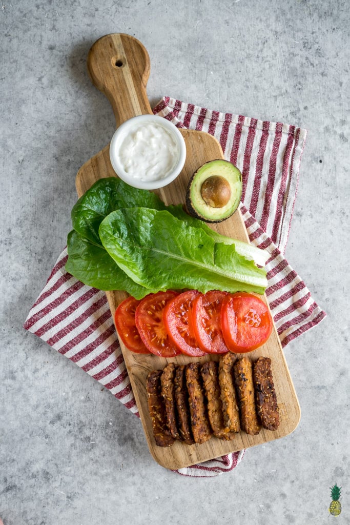 The viral TTLA sandwich from Whole Foods just made its way into your kitchen. Learn how to make this delicious vegan recipe from scratch, loaded with tempeh bacon, tomatoes, lettuce, avocado and a homemade garlic aioli. Get ready to dig into your new favorite sandwich! #vegan #sandwich #ttla #homemade #wholefoods #easyrecipe #healthyrecipe #veganlunch #veganentree #vegansandwich #restaurantstyle