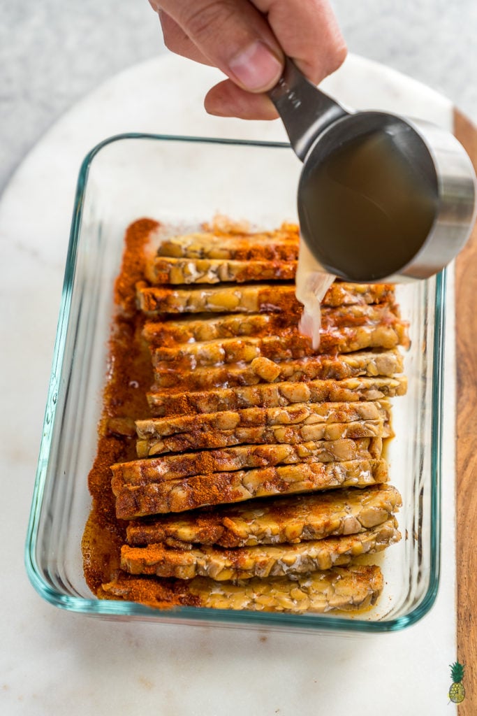 Making tempeh bacon at home is so easy and requires just 8 ingredients! Just whisk everything together, marinate it for a bit and cook it up to perfection. This is the perfect protein packed addition to your next breakfast! #tempeh #bacon #vegan #protein #easy #8ingredient #musttry #homemade #veganbreakfast #veganside #veganbacon #tempehbacon #howto #foolproof #easy