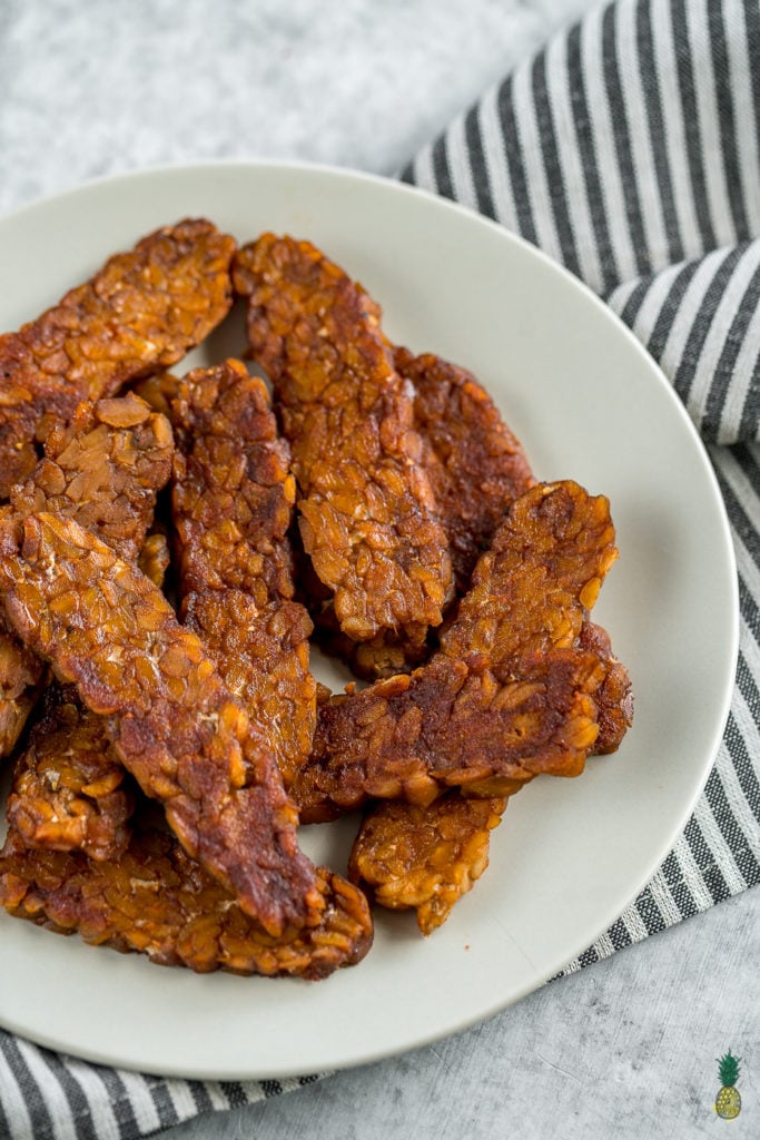 Making tempeh bacon at home is so easy and requires just 8 ingredients! Just whisk everything together, marinate it for a bit and cook it up to perfection. This is the perfect protein packed addition to your next breakfast! #tempeh #bacon #vegan #protein #easy #8ingredient #musttry #homemade #veganbreakfast #veganside #veganbacon #tempehbacon #howto #foolproof #easy