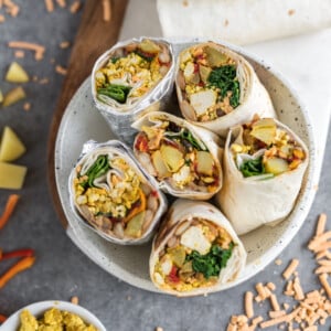 Easy and delicious vegan breakfast burritos that are loaded with breakfast potatoes, tofu scramble, homemade pinto beans and more! Plus, these burritos are freezer-friendly, so they make for the perfect make-ahead meal. #vegan #breakfast #burritos #loaded #freezerfriendly #onthego #bentobox #lunchbox #kids #veganlunch #tofuscramble #veganbreakfast