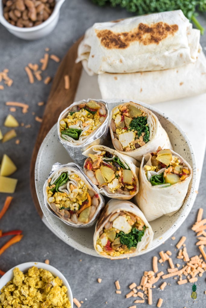 Easy and delicious vegan breakfast burritos that are loaded with breakfast potatoes, tofu scramble, homemade pinto beans and more! Plus, these burritos are freezer-friendly, so they make for the perfect make-ahead meal. #vegan #breakfast #burritos #loaded #freezerfriendly #onthego #bentobox #lunchbox #kids #veganlunch #tofuscramble #veganbreakfast