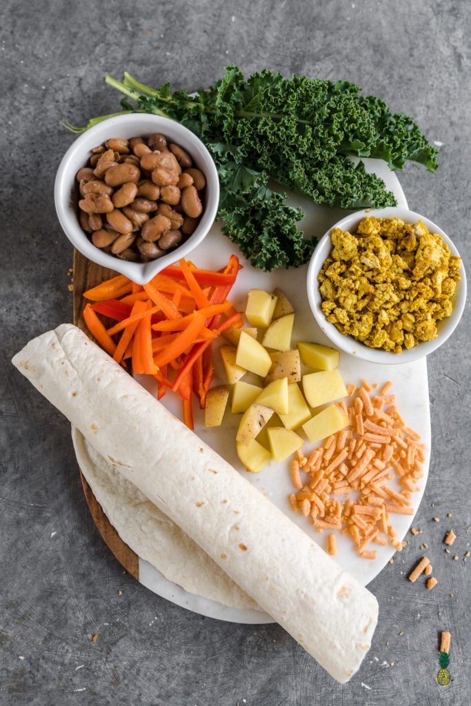 Easy and delicious vegan breakfast burritos that are loaded with breakfast potatoes, tofu scramble, homemade pinto beans and more! Plus, these burritos are freezer-friendly, so they make for the perfect make-ahead meal. #vegan #breakfast #burritos #loaded #freezerfriendly #onthego #bentobox #lunchbox #kids #veganlunch #tofuscramble #veganbreakfast