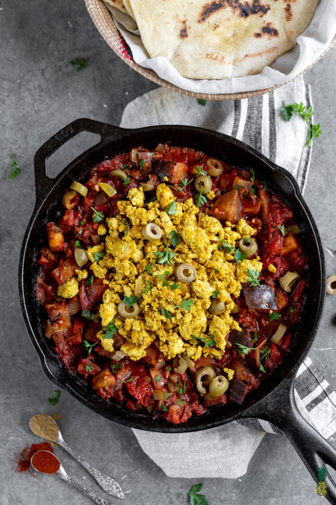 If you haven't had shakshuka before, you are in for a treat! This dish is loaded with a plethora of vegetables in a thick tomato sauce, topped with a flavor-packed tofu scramble, and ready in less than 30 minutes! #shakshuka #breakfast #lunch #dinner #tunisia #middleeastern #northafrica #israel #shakshouka #veganized #egg #tofuscramble #healthy #lowfat #30minute #meal #easy #sweetsimplevegan #entree #onthego #togo