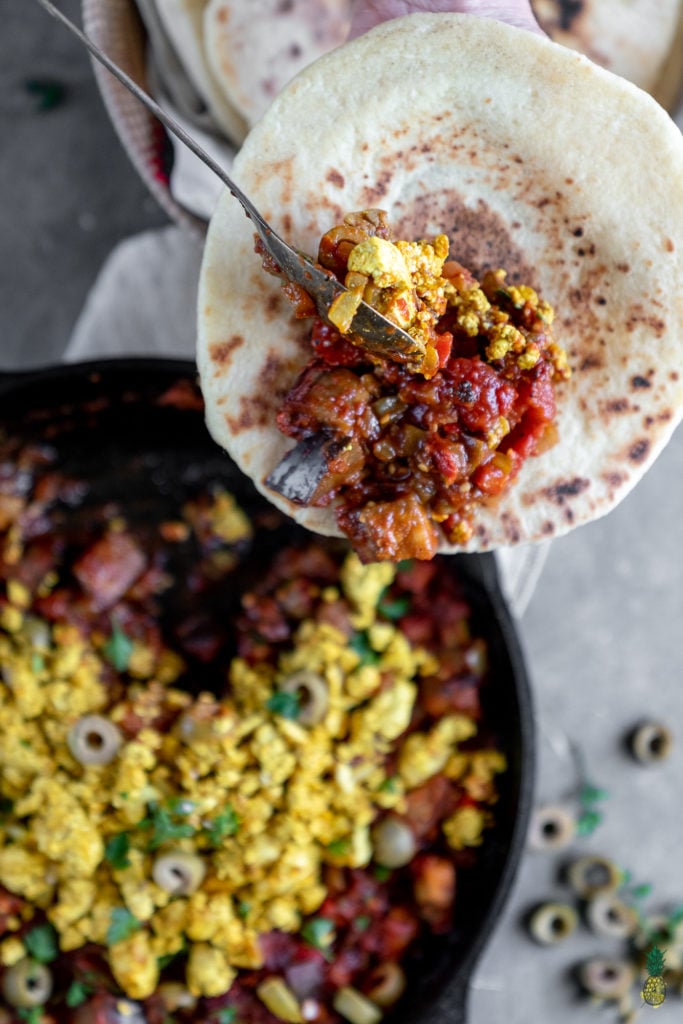 If you haven't had shakshuka before, you are in for a treat! This dish is loaded with a plethora of vegetables in a thick tomato sauce, topped with a flavor-packed tofu scramble, and ready in less than 30 minutes! #shakshuka #breakfast #lunch #dinner #tunisia #middleeastern #northafrica #israel #shakshouka #veganized #egg #tofuscramble #healthy #lowfat #30minute #meal #easy #sweetsimplevegan #entree #onthego #togo