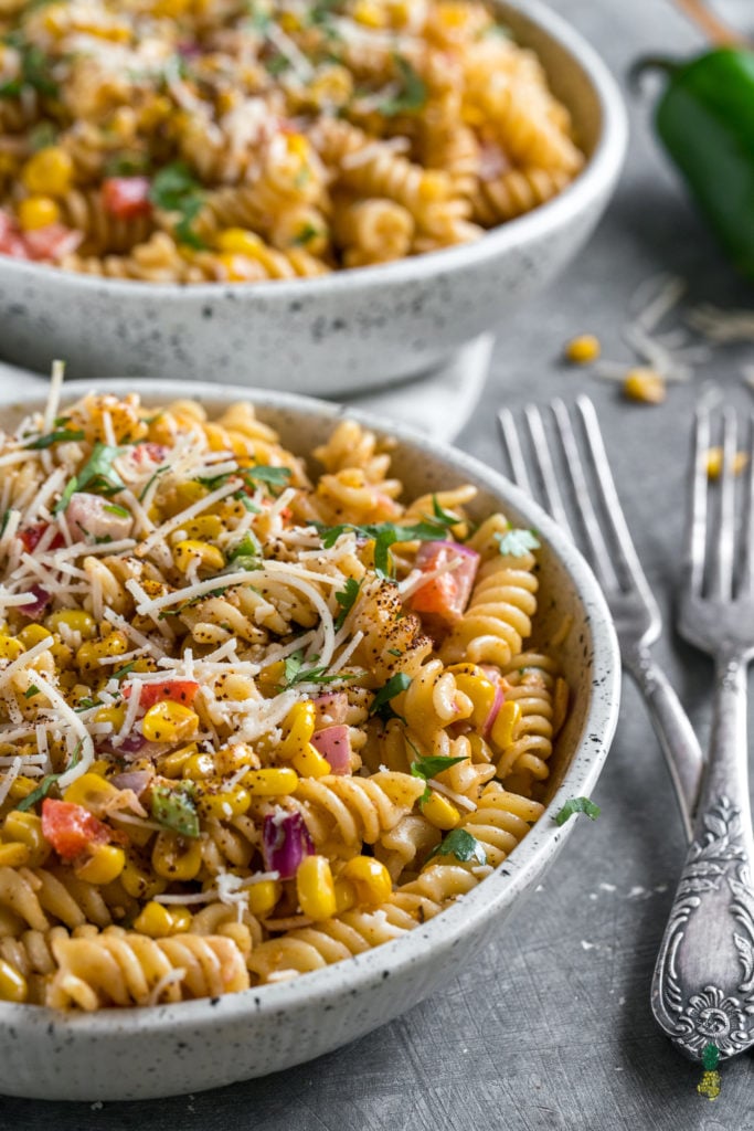 Macro shot of vegan spiral pasta with mexican street corn inspiration and parmesan cheese.