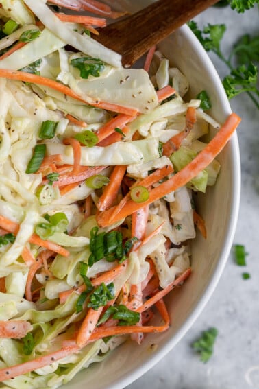 A quick & easy vegan coleslaw recipe just like what we remember digging into growing up. It's creamy and crunchy with the perfect amount of bite, plus it only takes 10 minutes to make! #thebest #vegan #coleslaw #summer #recipe #side #appetizer #pulledjackfruit #barbecue #sandwiches #salad #veganparty #lastminuterecipe #quickrecipe #easyvegan #sweetsimplevegan