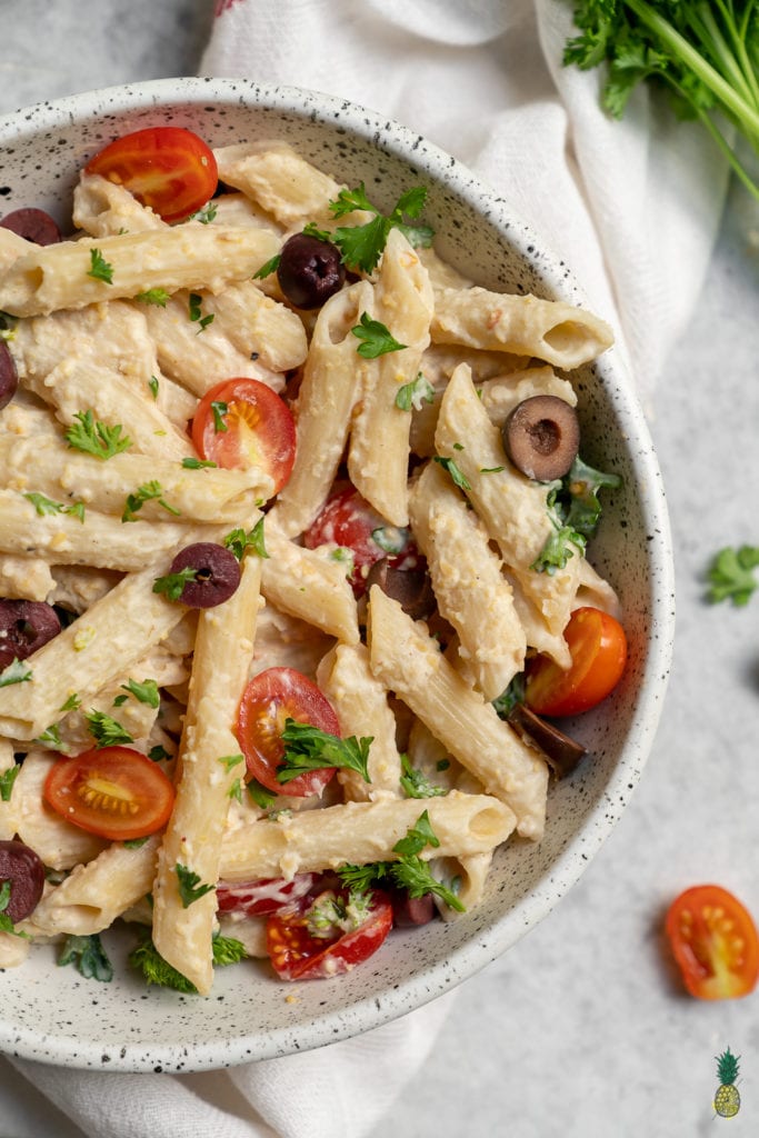 overhead image of big bowl of hummus past on styled gray background