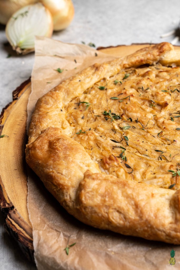 Caramelized onions paired with thyme and vegan cheese, all wrapped in a flaky homemade tart crust. Need I say more? This tart is perfect for entertaining guests and will be the hit of any party! #vegan #onion #tart #savorytart #side #appetizer #party #musttry #easy #veganpastry #veganized #bestofvegan #sweetsimplevegan #caramelized