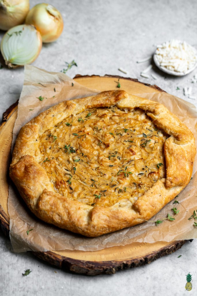 Caramelized onions paired with thyme and vegan cheese, all wrapped in a flaky homemade tart crust. Need I say more? This tart is perfect for entertaining guests and will be the hit of any party! #vegan #onion #tart #savorytart #side #appetizer #party #musttry #easy #veganpastry #veganized #bestofvegan #sweetsimplevegan #caramelized