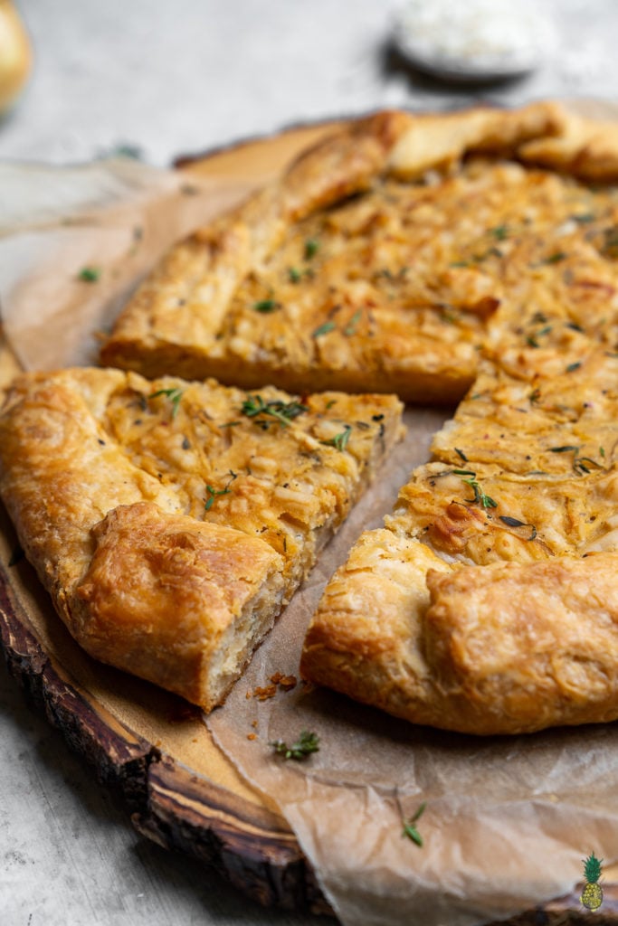 Caramelized onions paired with thyme and vegan cheese, all wrapped in a flaky homemade tart crust. Need I say more? This tart is perfect for entertaining guests and will be the hit of any party! #vegan #onion #tart #savorytart #side #appetizer #party #musttry #easy #veganpastry #veganized #bestofvegan #sweetsimplevegan #caramelized