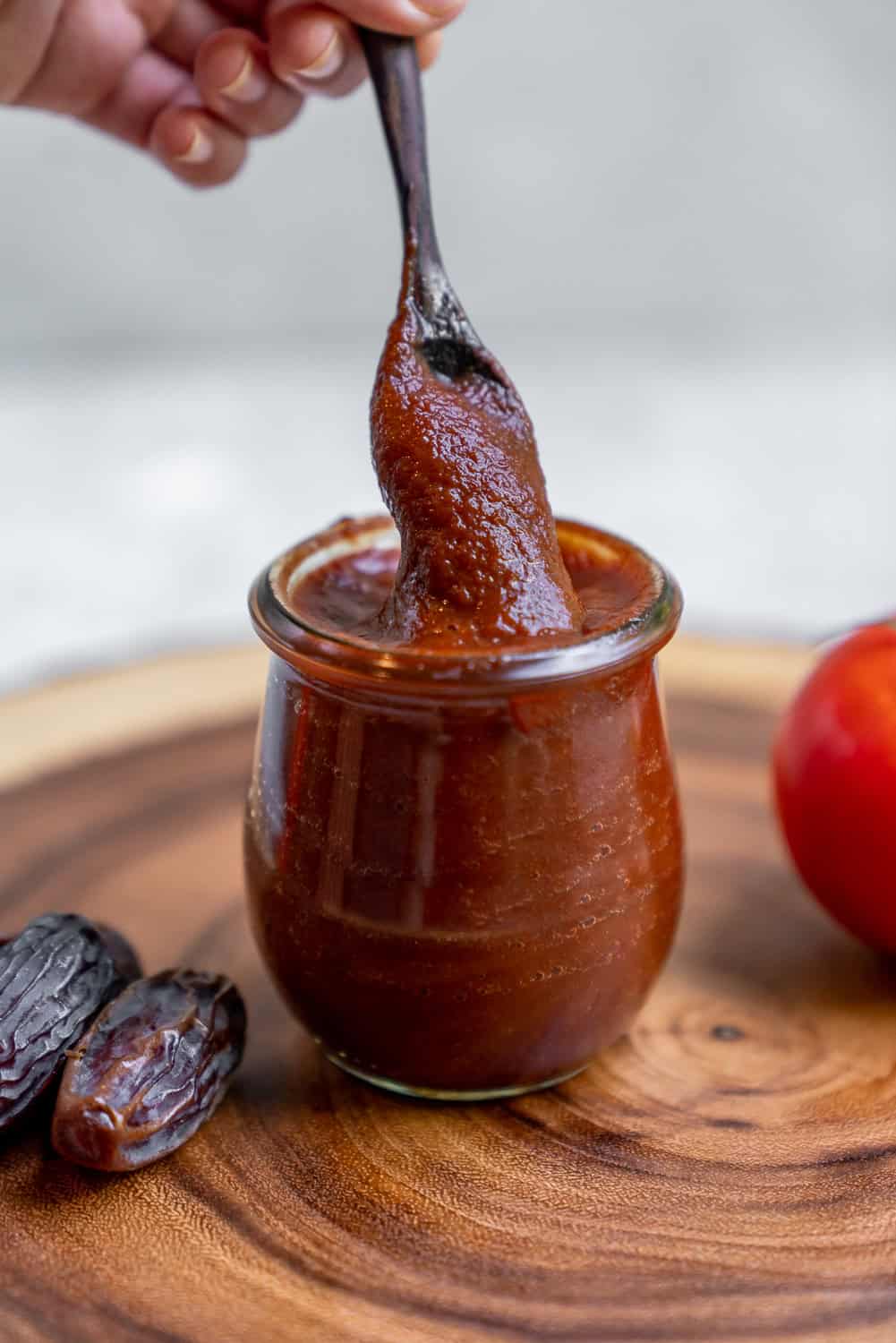 barbecue sauce in a glass weck jar with a wooden spoon