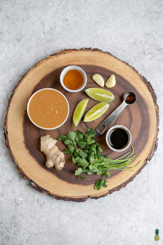 overhead image of ingredients for peanut sauce on wood board. 