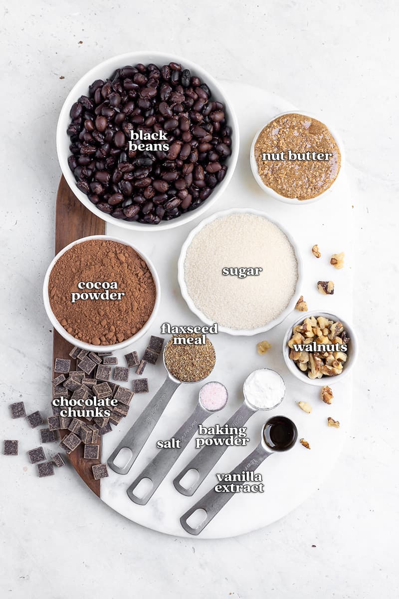 labeled ingredients for black bean brownies on white marble board