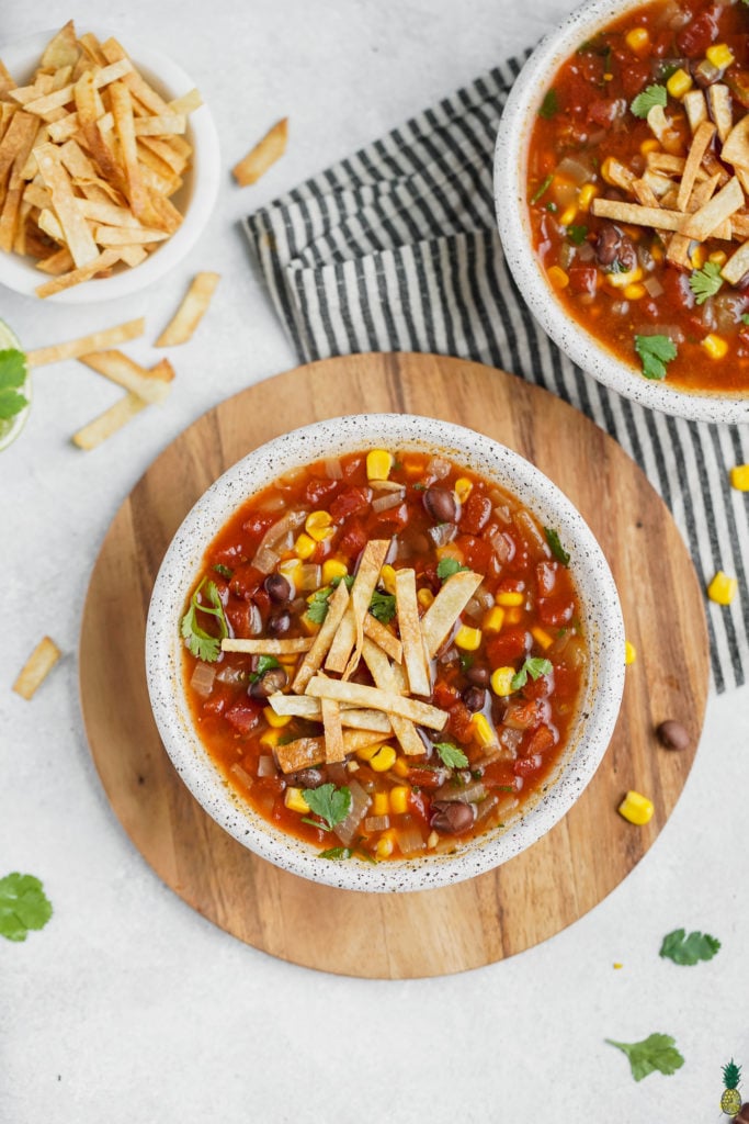A bowl of vegan tortilla soup with garnishes