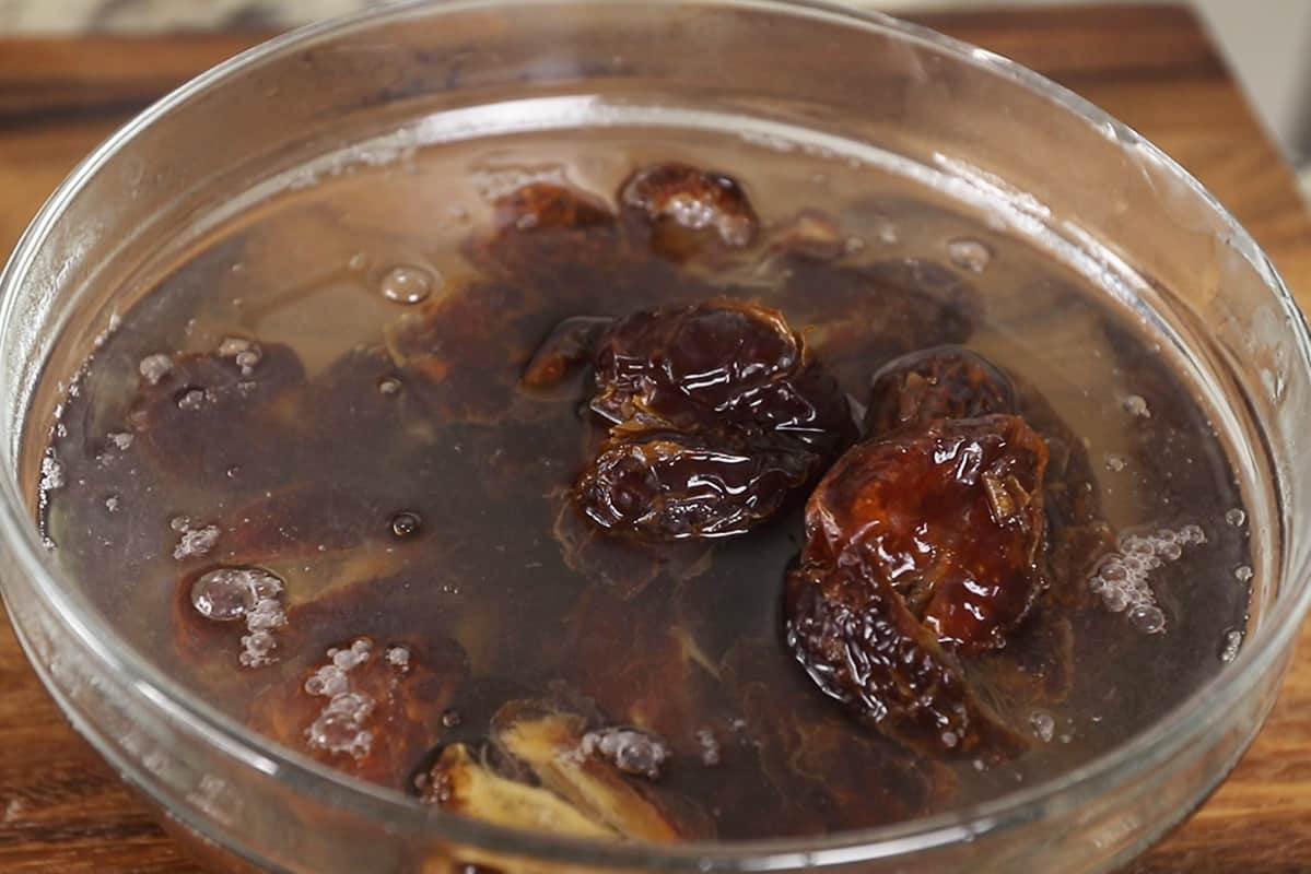 soaking pitted medjool dates in hot water in a glass bowl
