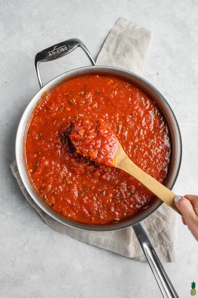 Mixing homemade chunky marinara sauce in a stainless steel pan