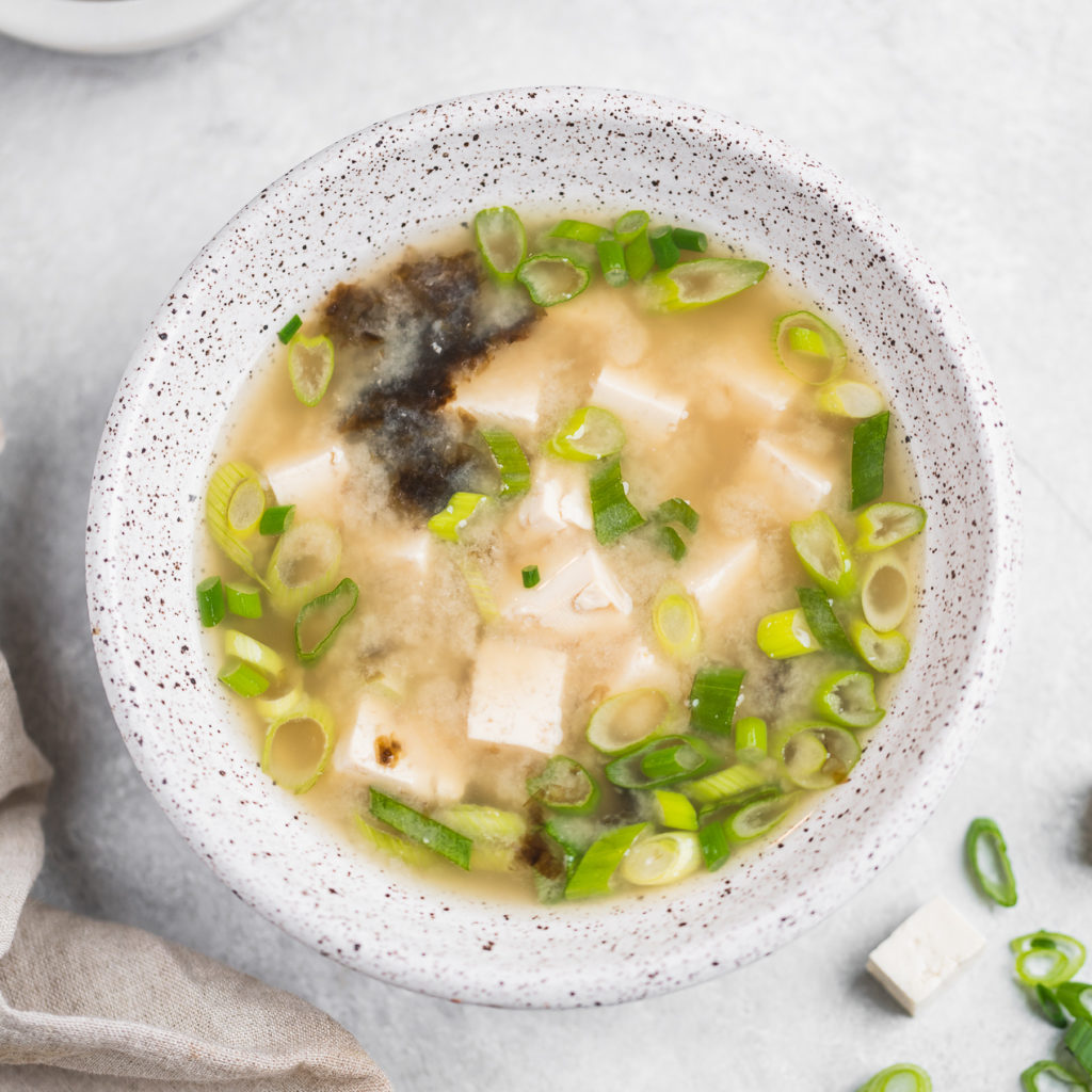 Miso soup with tofu in white bowls, vegan, close up