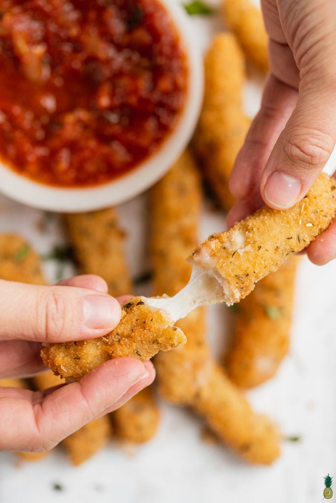 Stretchy cheese in a mozzarella stick with marinara sauce