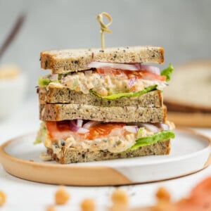 Vegan chickpea tuna salad sandwich on a plate and cut on the Sweet Simple Vegan Blog