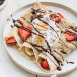 Vegan French crepes topped with whipped cream, chocolate syrup and fresh fruit. Sweet Simple Vegan Blog