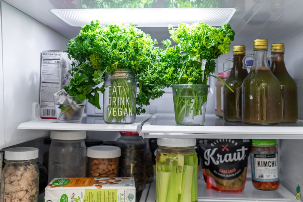 Herbs in jars with water in the refrigerator