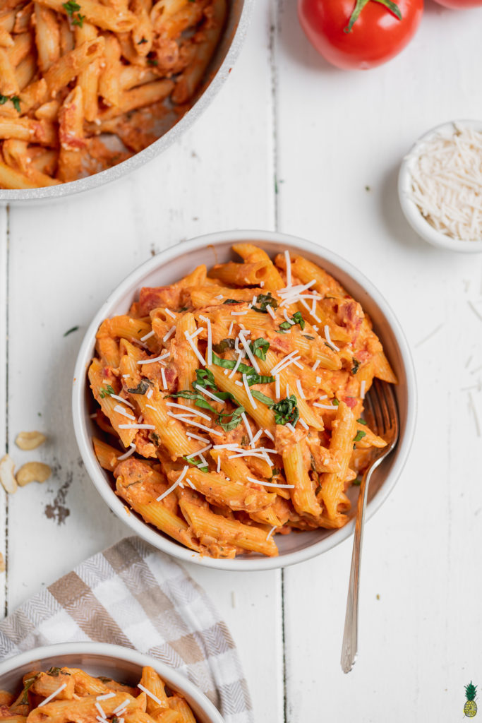 Overhead shot of vegan penne alla vodka in a bowl with a fork by sweet simple vegan
