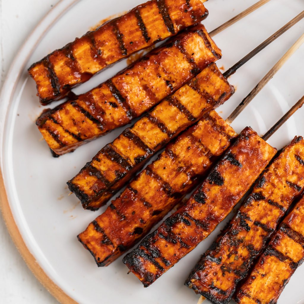 overhead photo of grilled barbecue tofu skewers on plate
