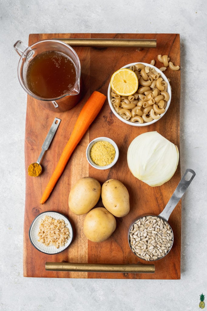 Ingredients to make vegan mac and cheese on a wooden board by sweet simple vegan blog