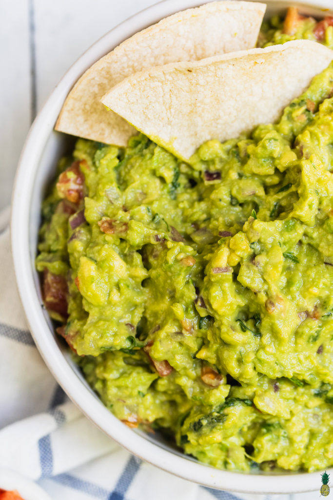 A closeup shot of guacamole with tortilla chips by Sweet Simple Vegan