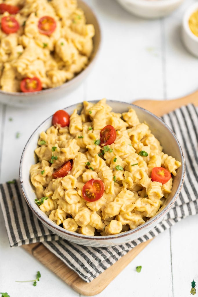 5-ingredient creamy white bean pasta in a bowl close up with tomatoes on top by sweet simple vegan