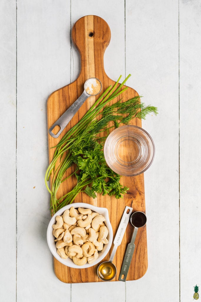 Ingredients to make cashew ranch dressing on a wooden board by sweet simple vegan