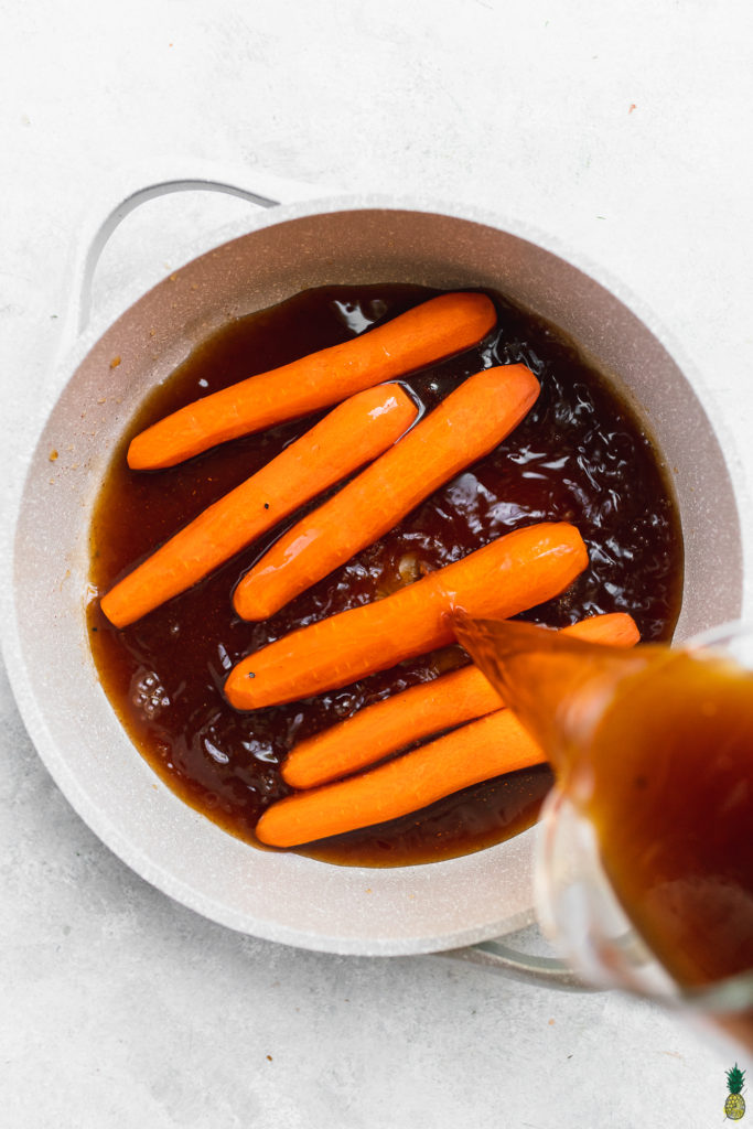 Marinade being poured over carrots in a pot to make vegan carrot hot dogs