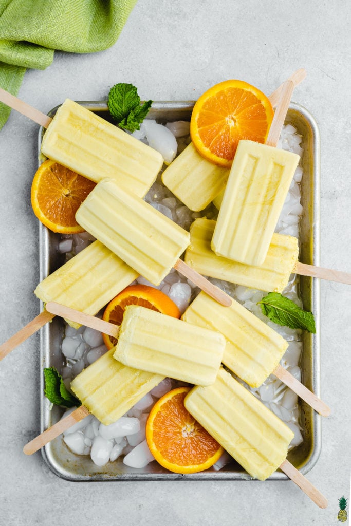 5 ingredient vegan orange creamsicle popsicles on a tray by sweet simple vegan