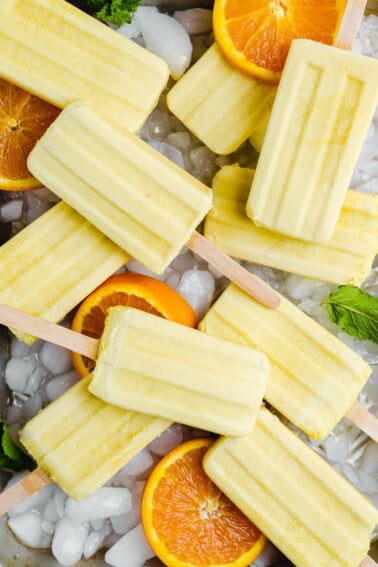 5 ingredient vegan orange creamsicle popsicles on a tray by sweet simple vegan