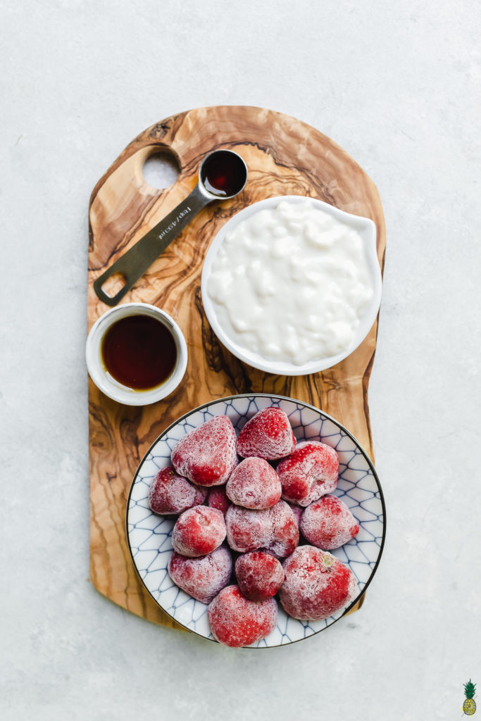 Ingredients to make vegan frozen yogurt on a wooden board by sweet simple vegan