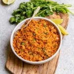 Homemade Spanish Rice in a white bowl with a serving spoon