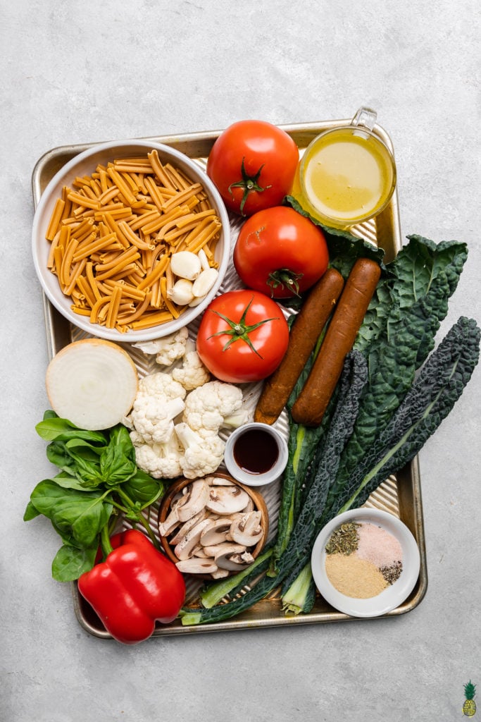 Fresh ingredients on a sheet pan to make an easy vegan sheet pan pasta recipe by sweet simple vegan