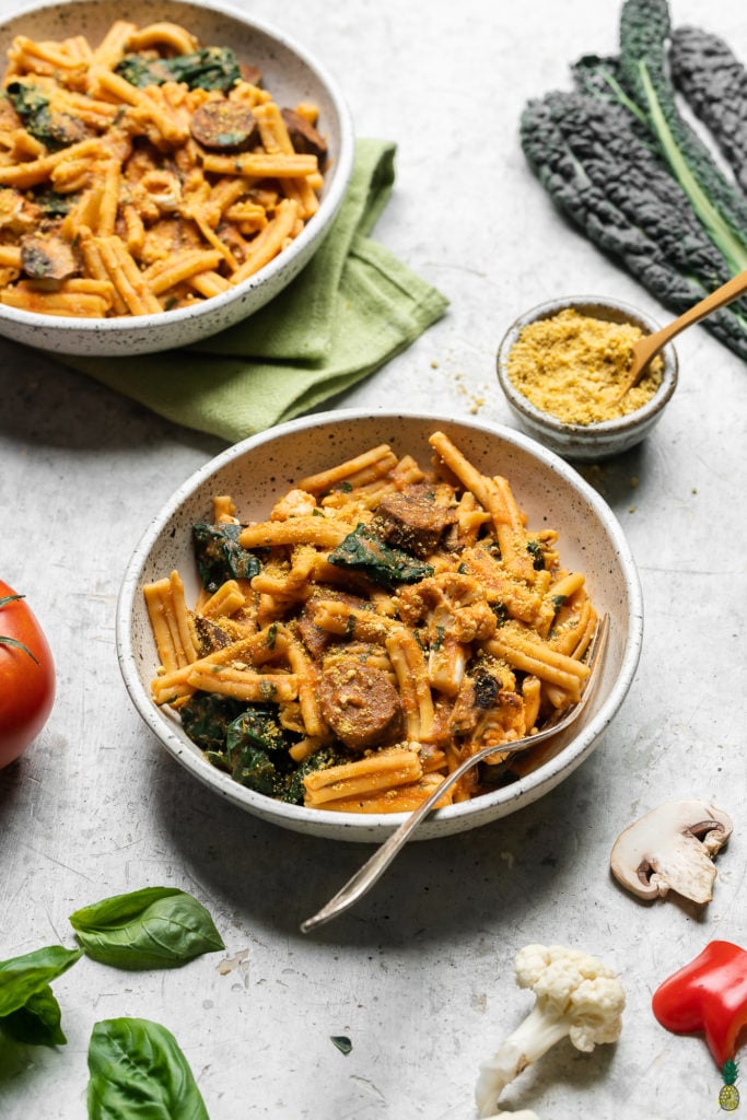 Gluten free pasta with roasted red pepper and tomato sauce in a ceramic bowl; food photograph by sweet simple vegan