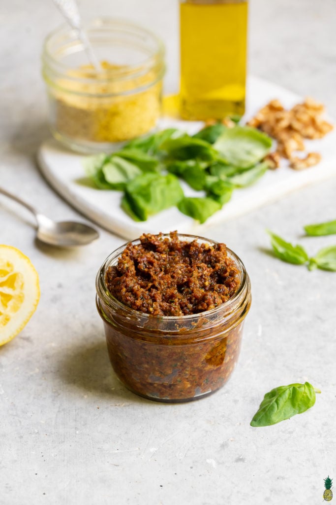 A jar of vegan sun dried tomato pesto food photography