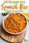 Homemade Spanish Rice in a white bowl with a serving spoon for pinterest