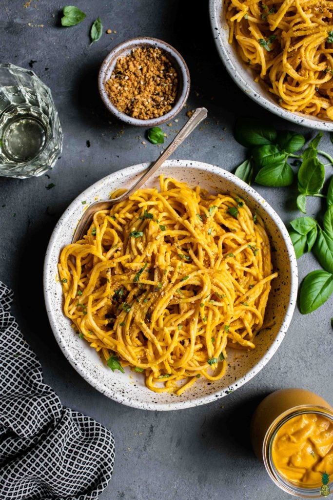 a white bowl of creamy vegan squash pasta with parmesan and white wine by sweet simple vegan