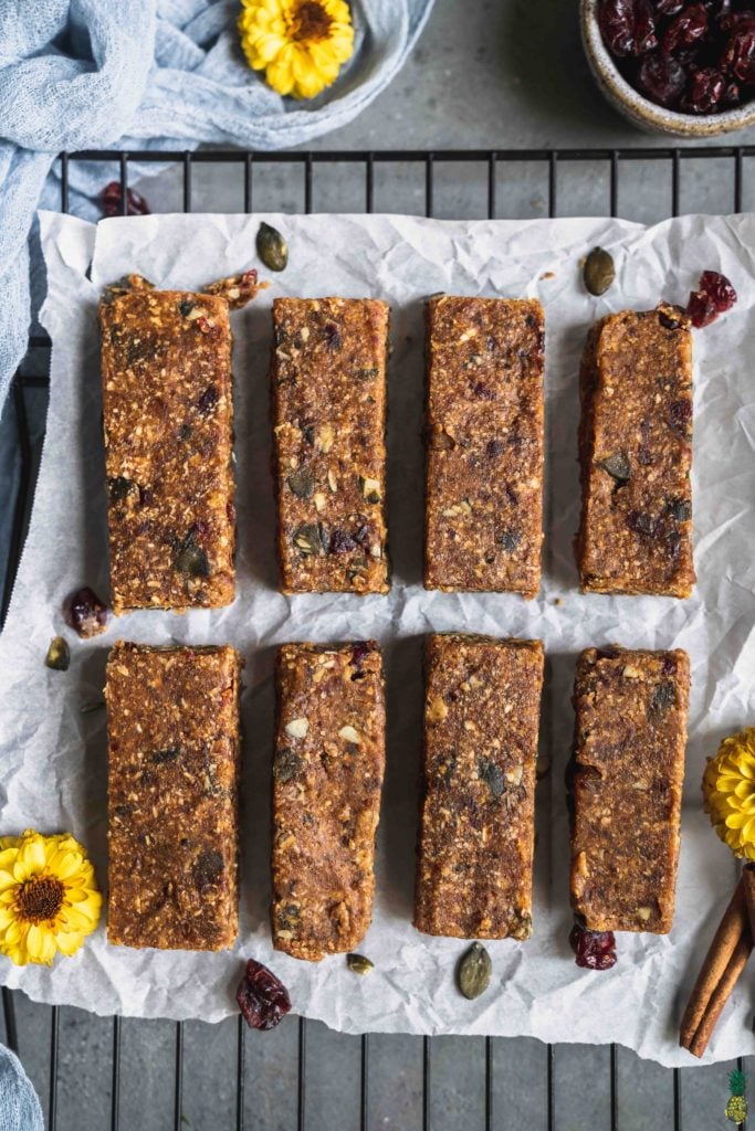 no bake peanut butter breakfast bars on parchment paper with flowers by sweet simple vegan