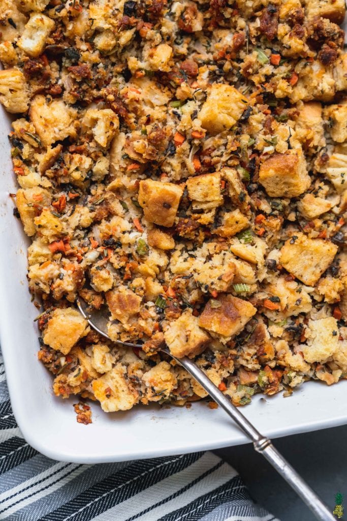 Closeup shot of a buttermilk biscuit thanjsgiving stuffing with vegetables and herbs by sweetsimplevegan